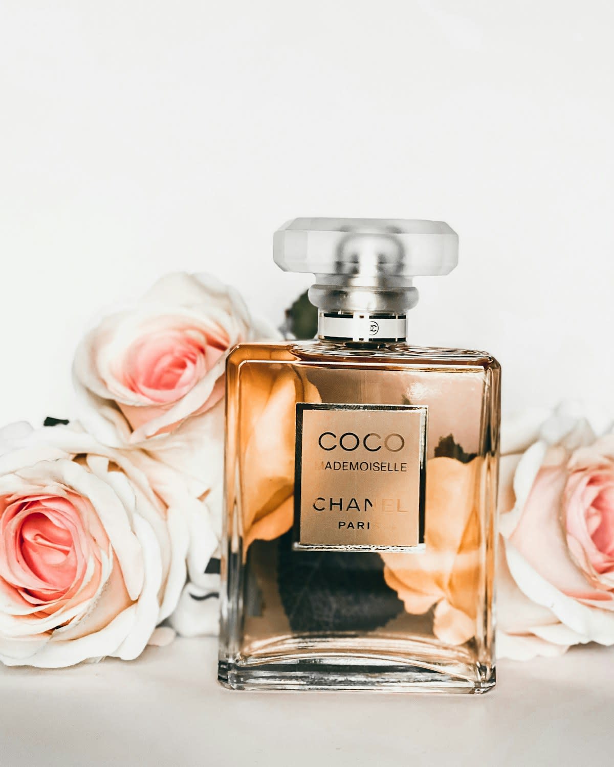 Clear glass perfume bottle with a golden liquid on a stone surface