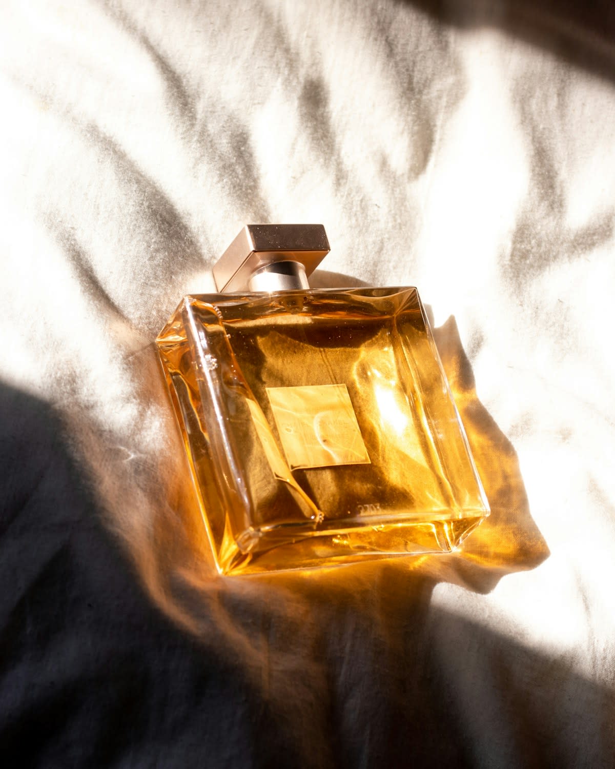 Perfume bottle beside fresh figs and leaves