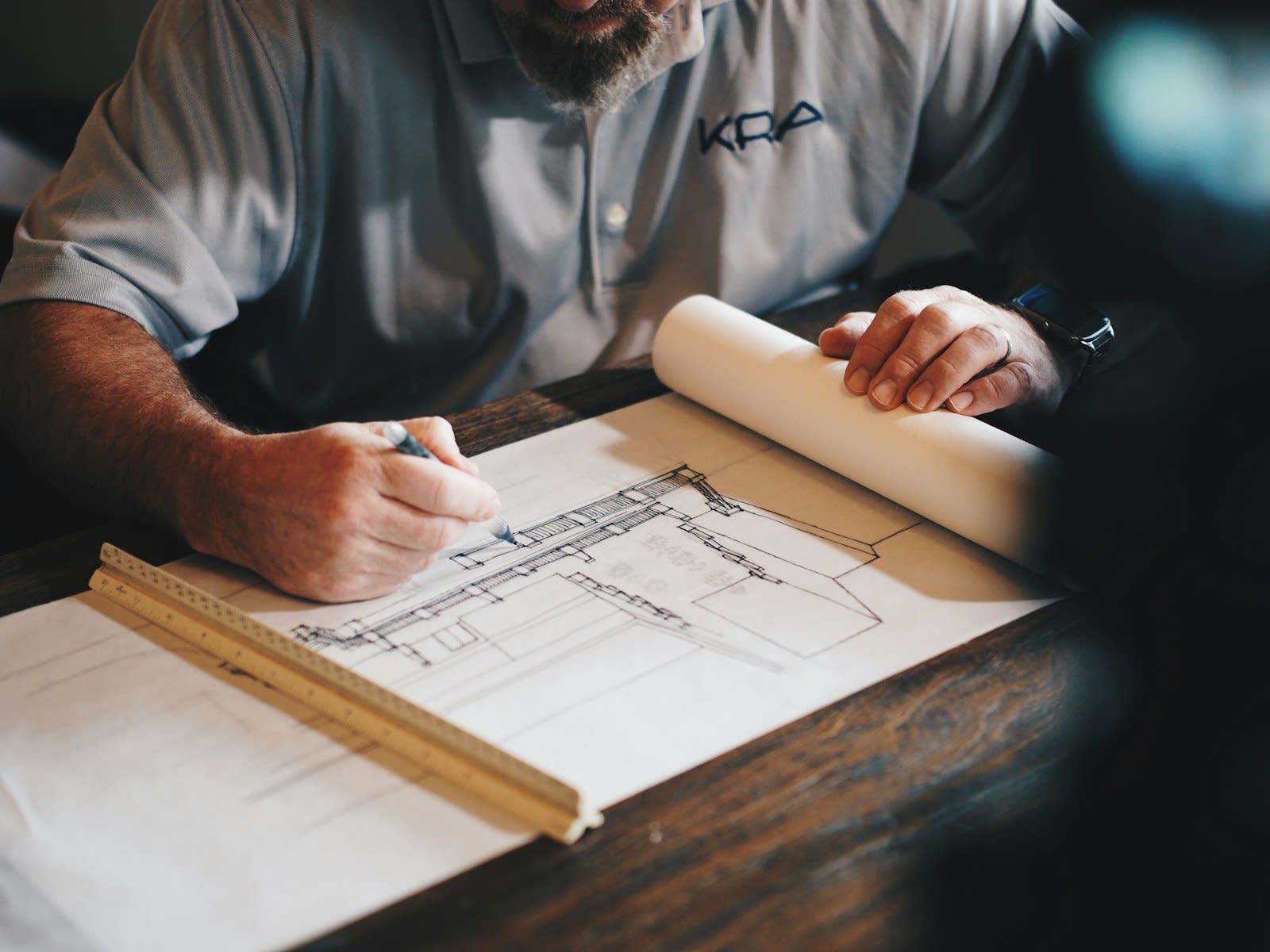 Architects around a table with drawings and a model