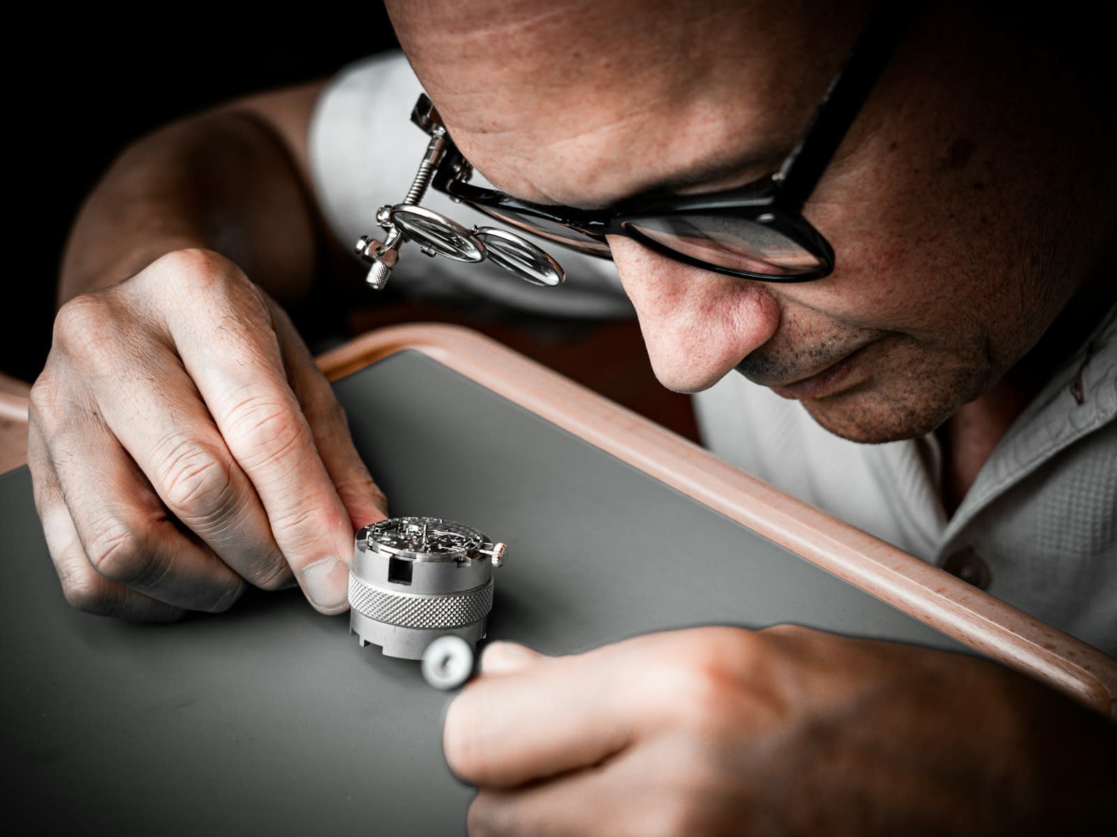 Watchmaker at a bench with a loupe