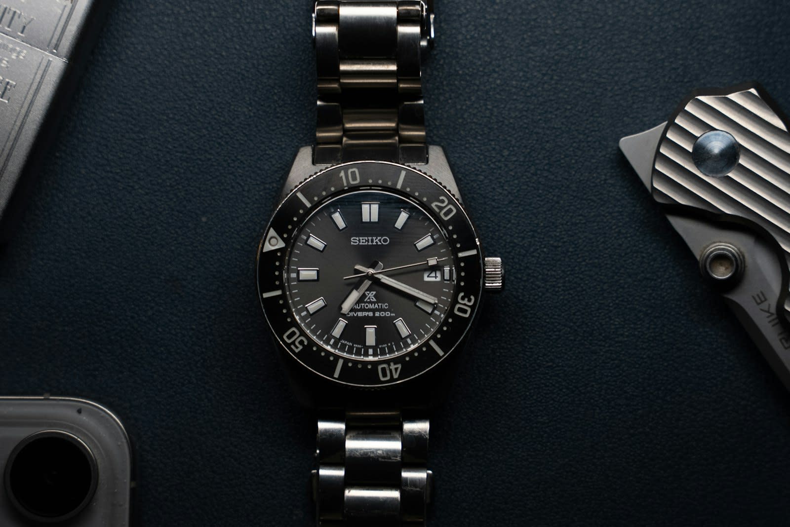 Steel wristwatch with a dark dial on a leather strap