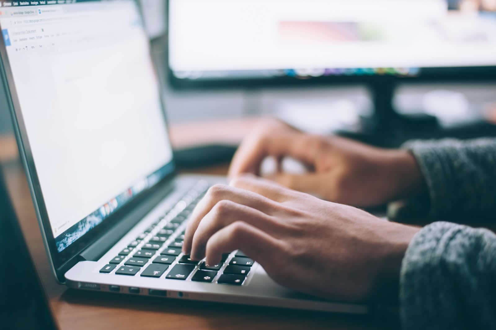 Hands typing an email on a laptop