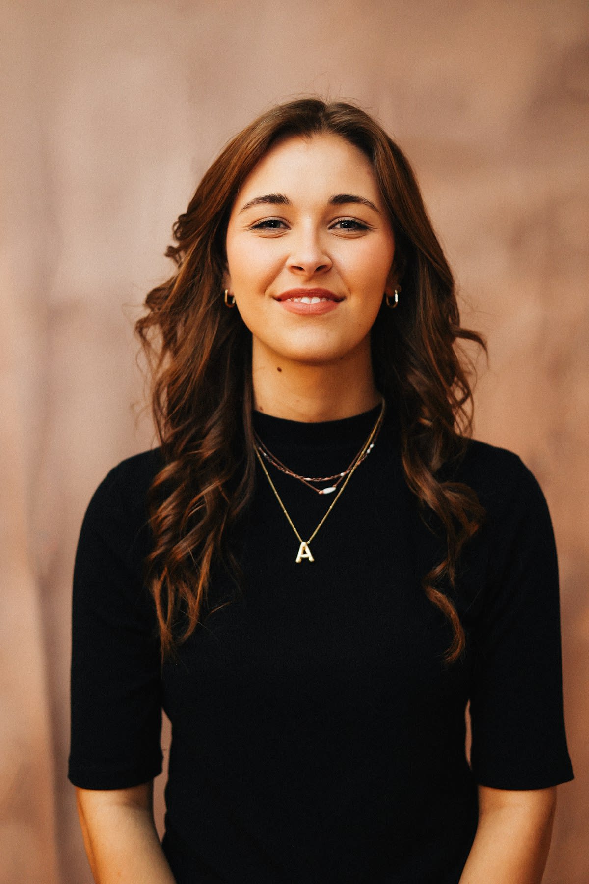 Amina, smiling, in a warm studio portrait