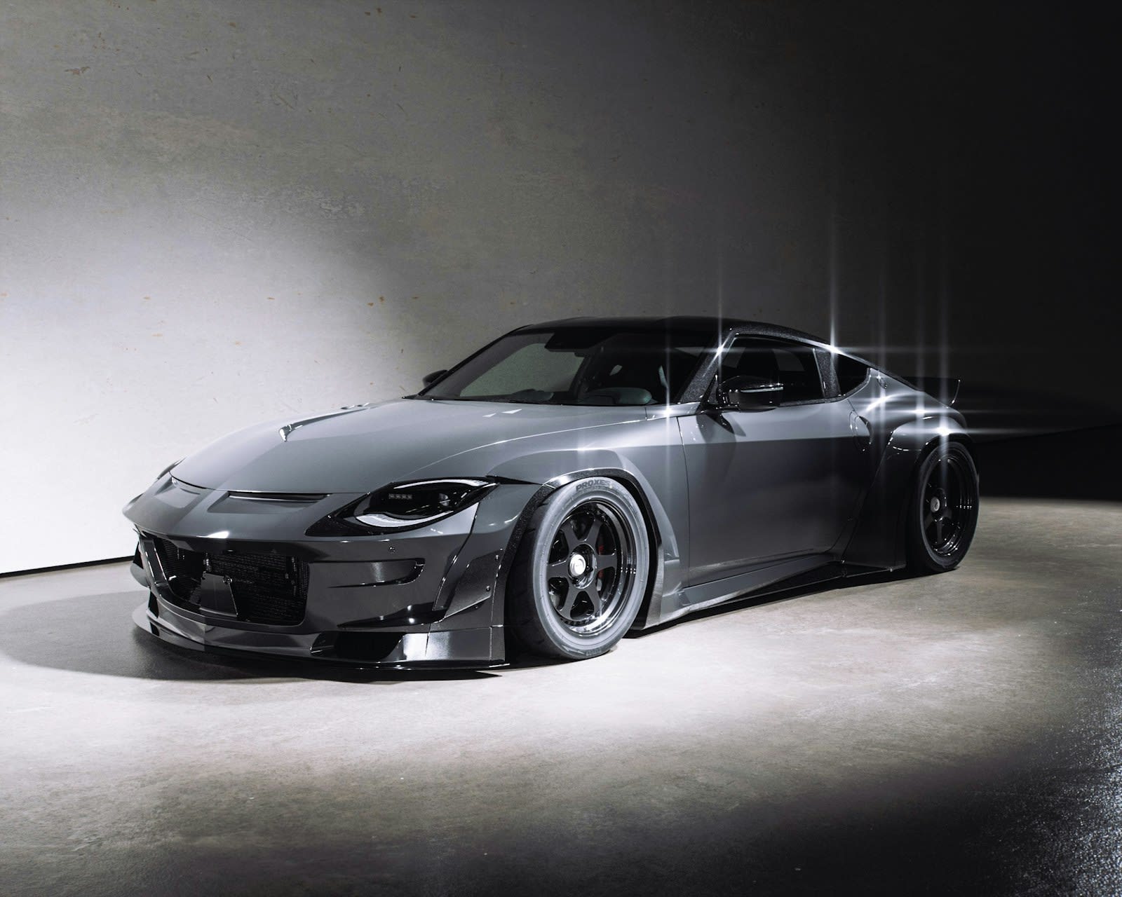Dark grey sports car photographed in a studio